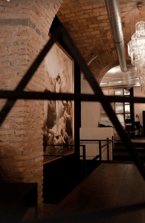 Aria studio interior — leather chair, brick arch, warm bronze light.